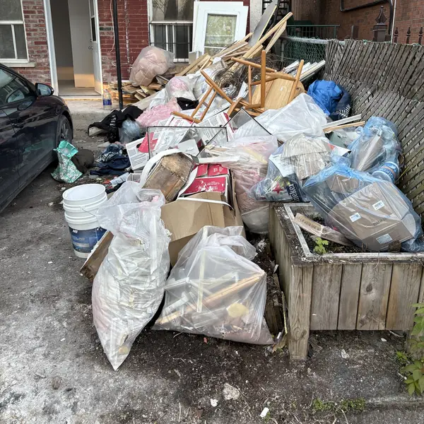 Before: Montréal plex backyard clear-out: bags, lumber and furniture, then an empty yard.