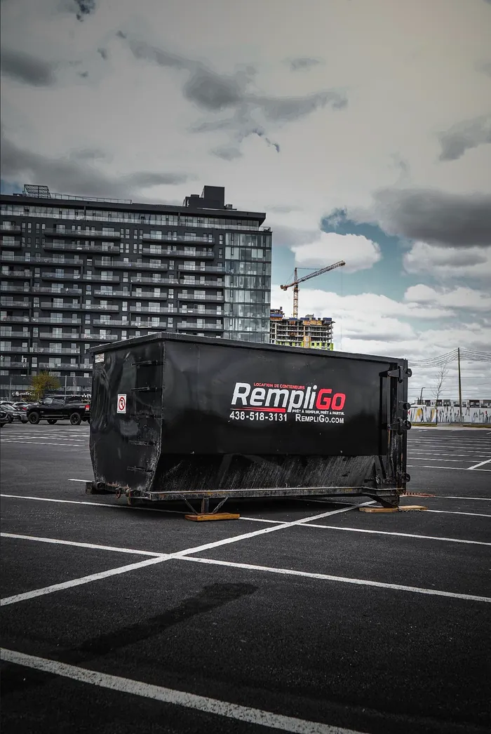 RempliGo 20-yard dumpster in a parking lot near a condo construction site